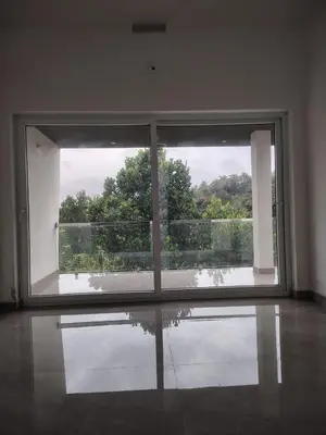 an empty room with a large window with a view at Savisos home in Padinjarathara