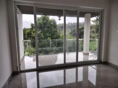 an empty room with an open window with a view at Savisos home in Padinjarathara