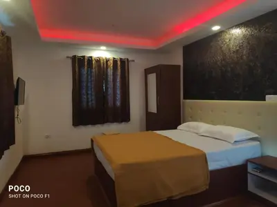 a hotel room with two beds and a red ceiling at Lush Green View Cottage 3BH in Ooty