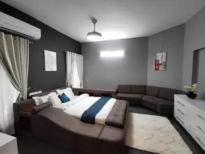 a living room with a bed and a couch at Karthika Residency Parakkadavu in Nedumbassery