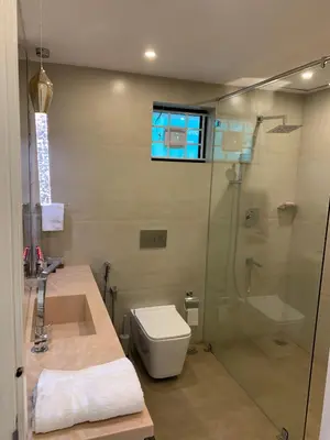 a bathroom with a shower and a toilet and a sink at Karthika Residency Parakkadavu in Nedumbassery