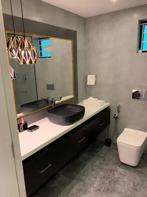 a bathroom with a black sink and a mirror at Karthika Residency Parakkadavu in Nedumbassery