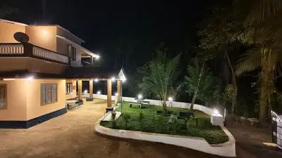 a house with a courtyard at night at Dreamland kizhunna beach homestay in Kannur