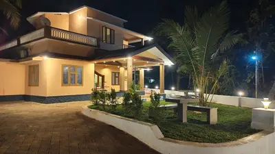 a house with a bench in front of it at night at Dreamland kizhunna beach homestay in Kannur