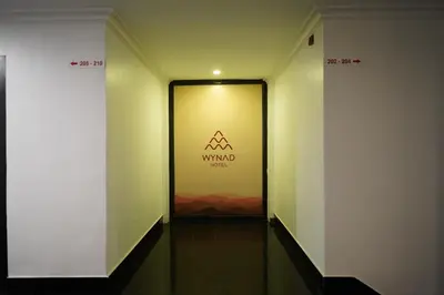 a hallway with a door with a sign on it at Wynad Hotel in Kozhikode