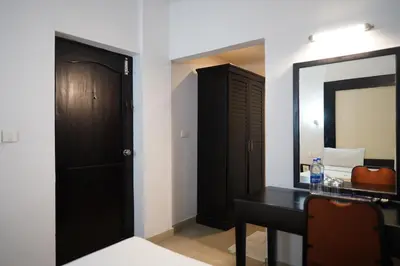 a bathroom with a black vanity and a mirror at Wynad Hotel in Kozhikode