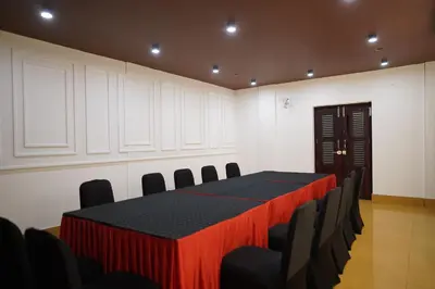 a conference room with a table and chairs at Wynad Hotel in Kozhikode