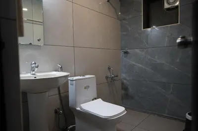 a bathroom with a toilet and a sink and a shower at Wynad Hotel in Kozhikode