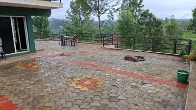 a patio of a house with a table and chairs at Greenary homestay in Ooty