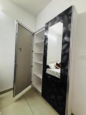 a walk in closet with a glass door and shelves at Merrat Regency in Trichūr