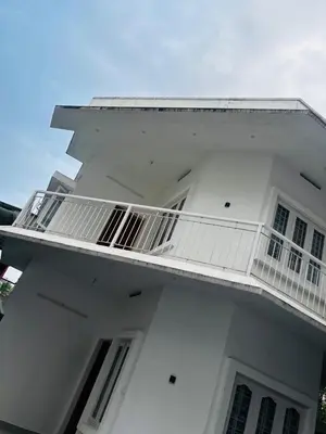 a white building with a balcony on the side of it at Merrat Regency in Trichūr