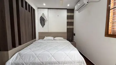 a bedroom with a large white bed in it at Shan Home Stay in Mysore