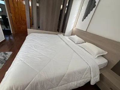 a large white bed with pillows in a bedroom at Shan Home Stay in Mysore