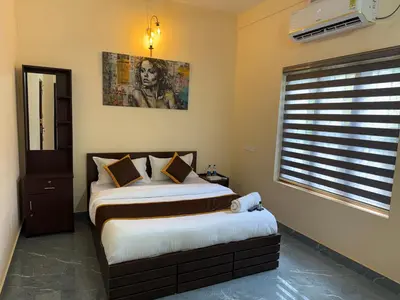 a bedroom with two beds and a window at Ethnic Family Spot Wayanad in Kenichira
