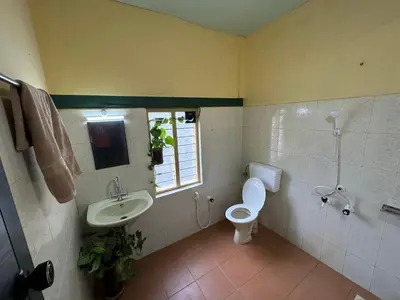 a bathroom with a sink and a toilet and a window at Massbungalow in Tindummal