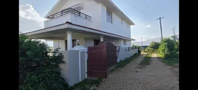 a white house with a gate and a fence at Sathya Holidays Evermist Stay in Ooty