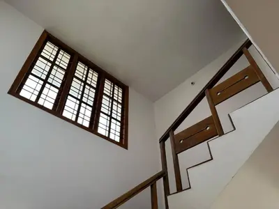 two windows in a white room with stairs at Sathya Holidays Evermist Stay in Ooty