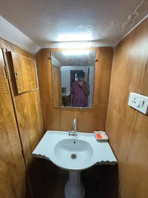 a person taking a picture of a sink in a bathroom at Sathya Holidays Evermist Stay in Ooty