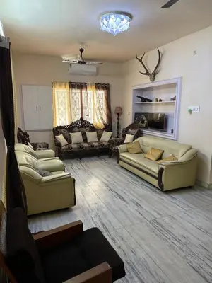 a large living room with couches and a fireplace at Rose villa in Coimbatore