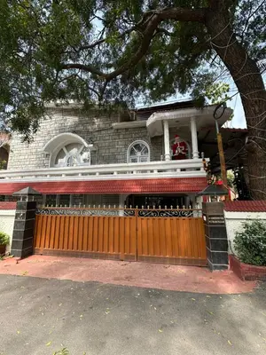 a house with a wooden gate in front of it at Rose villa in Coimbatore