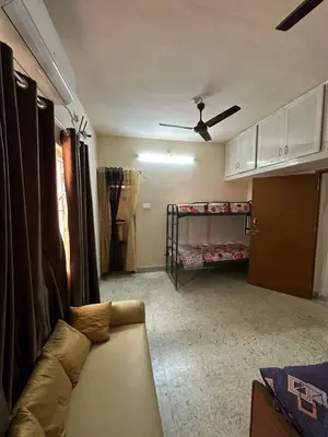 a living room with a couch and a bunk bed at Rose villa in Coimbatore
