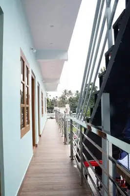 a corridor of a building with a wooden walkway at Carmel Cottage in Marayoor
