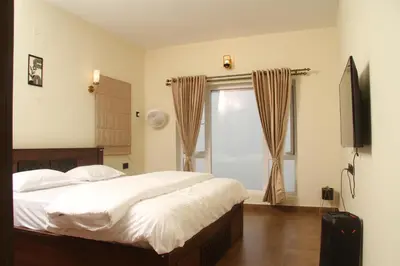 a bedroom with a bed and a television and a window at Luxurious Private Vantage Villa - Kotagiri in Kotagiri