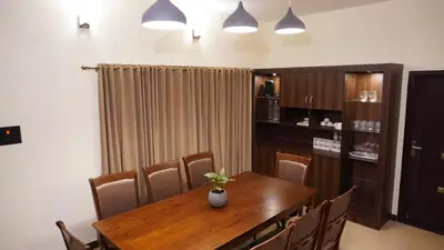 a dining room with a wooden table and chairs at Luxurious Private Vantage Villa - Kotagiri in Kotagiri