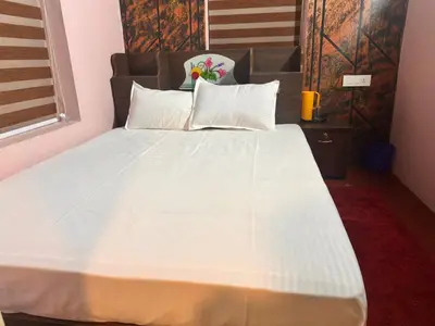 a bed with white sheets and pillows in a room at Bucolic Resort in Panamaram