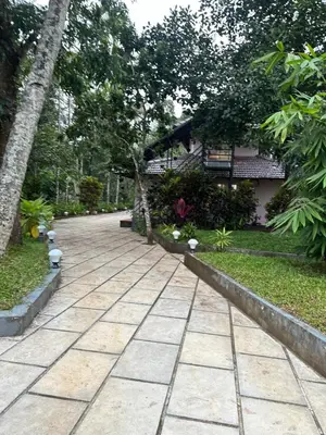 a stone walkway in front of a house at Bucolic Resort in Panamaram