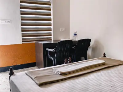 a bedroom with a bed with a chair and a table at Bamboo villa in Cochin