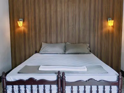 a bedroom with a bed with a wooden wall at Bamboo villa in Cochin
