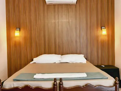 a bed in a room with a wooden wall at Bamboo villa in Cochin