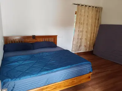 a bedroom with a bed with a blue comforter at River View Resort, Nilambur in Nilambūr
