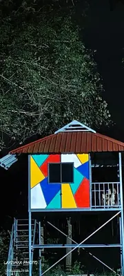 a colorful house with a roof next to a tree at River View Resort, Nilambur in Nilambūr