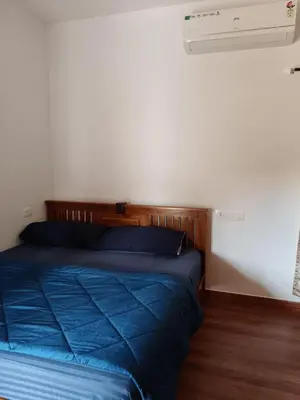 a bed with a blue comforter in a bedroom at River View Resort, Nilambur in Nilambūr