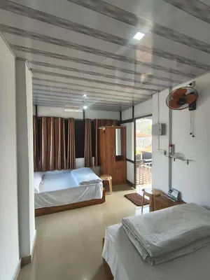 a bedroom with two beds and a balcony at Sleek Haven in Meppādi
