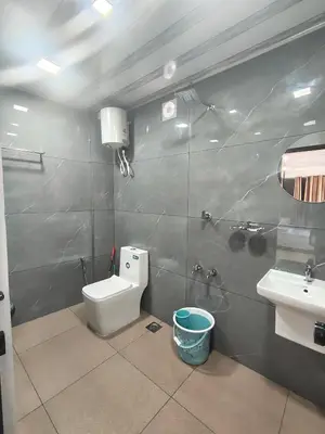 a bathroom with a toilet and a sink at Sleek Haven in Meppādi