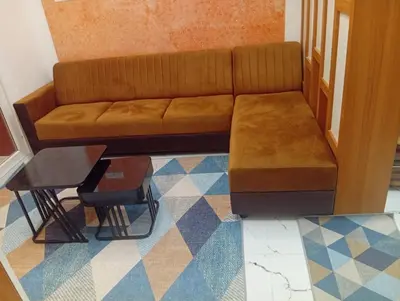 a brown couch sitting in a room with a table at Gurunandanam-Fully furnished Deluxe Apartment East Nada Guruvayur in Guruvāyūr