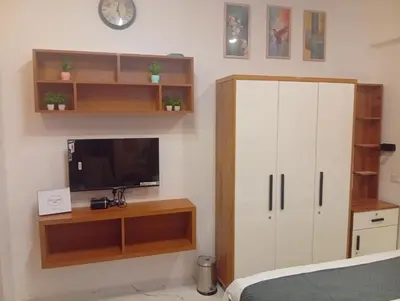 a bedroom with a tv and a white cabinet at Gurunandanam-Fully furnished Deluxe Apartment East Nada Guruvayur in Guruvāyūr