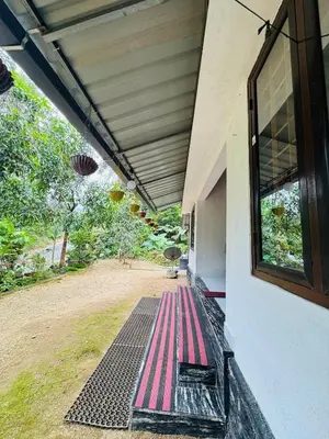 an outside porch of a house with a window at Parathanathu Homestay in Viripara