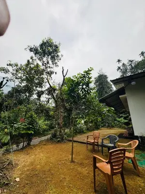 a group of chairs and a table in a yard at Parathanathu Homestay in Viripara