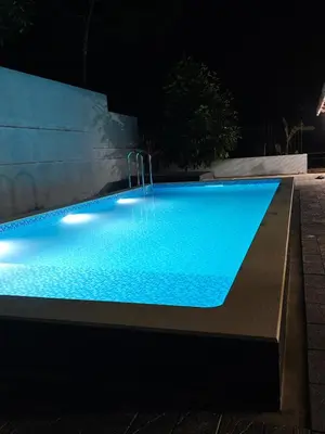 a swimming pool lit up at night at Havenza Homestayz in Athirappilly