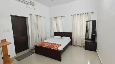 a bedroom with a bed and a mirror in it at Havenza Homestayz in Athirappilly