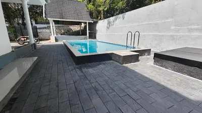 a swimming pool sitting next to a concrete wall at Havenza Homestayz in Athirappilly