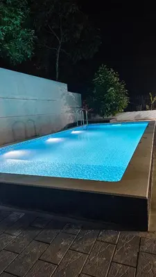 a swimming pool with a fountain in a yard at Havenza Homestayz in Athirappilly