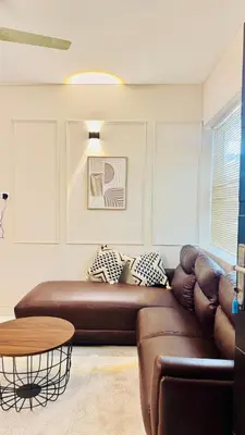a living room with a brown couch and a table at BOHO Living Kochi Airport in Ernakulam