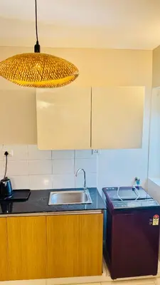 a kitchen with a sink and a light fixture at BOHO Living Kochi Airport in Ernakulam