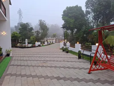 a walkway with benches and candles in a building at RiverBank Gardens, Mananthavady, Wayanad in Mananthavady