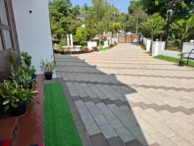 a walkway with plants on the side of a building at RiverBank Gardens, Mananthavady, Wayanad in Mananthavady